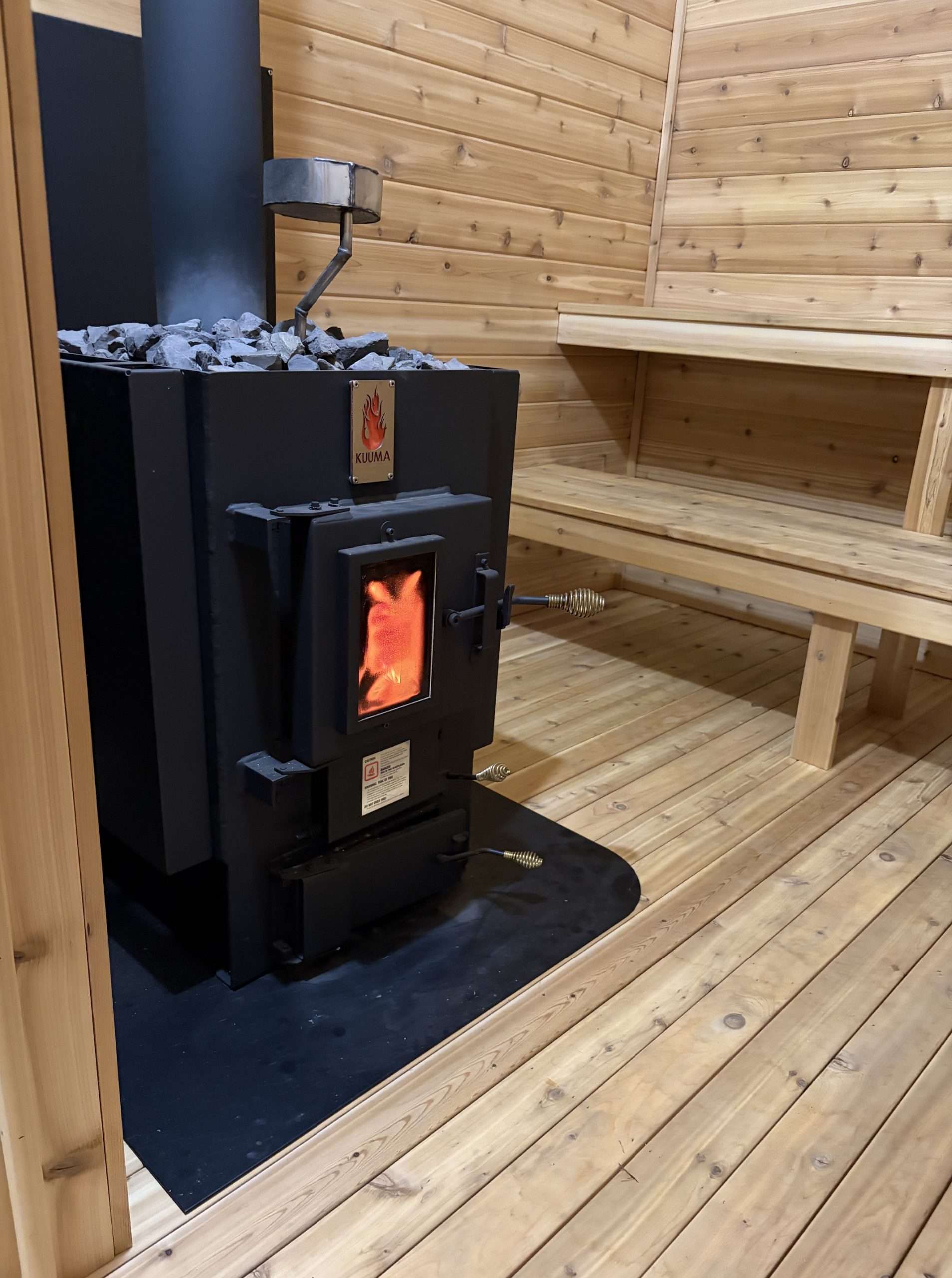 Classic Kuuma Legacy sauna stove burning inside a finished wood-fired sauna in Farmington, Minnesota